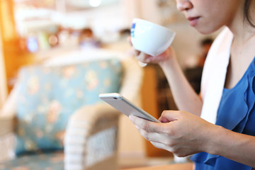 woman using internet mobile phone technology in cafe coffee