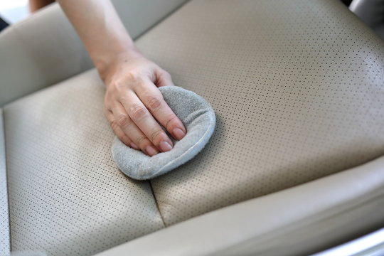 Woman Hand Cleaning Leather Seat In Car