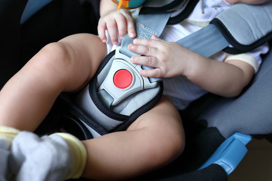 baby child sitting in car seat with safety belt locked protection