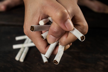 Hands clenched the cigarette tight. Concept stop smoking.