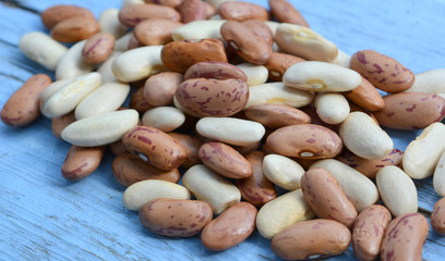 Beautiful composition: organic brown and white beans close-up isolated on blue wooden background, food