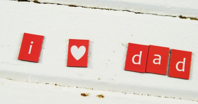 Text I love dad arranged on blocks arranged on wooden plank