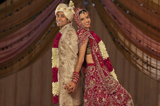 Portrait of newly married Indian couple holding hands 