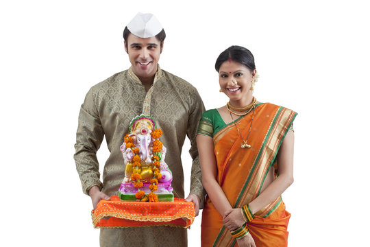 Portrait of a Maharashtrian couple with a Ganesh idol