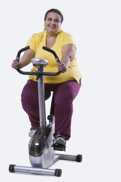 Portrait of an overweight woman exercising over white background 