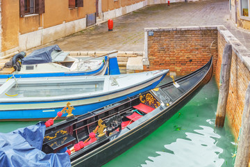 Fototapeta na wymiar Views of the most beautiful channels of Venice, empty gondola near the Pier. Venice, Italy.