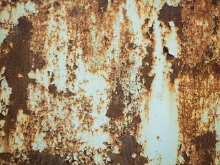 Texture of old rusty metal with streaks of rust and cracked, flaking paint. Surface of rusty metal close-up with old and faded paint.