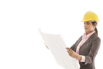 Female engineer reading blueprints 