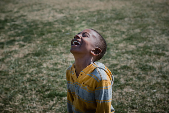 boy with joyful expression laughing outside 