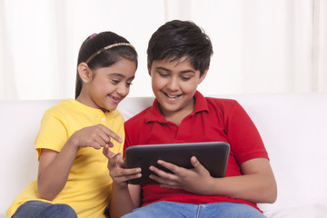 Fototapeta premium Brother and sister using digital tablet
