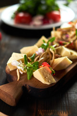 Pieces of cheese on a board with vegetables hd