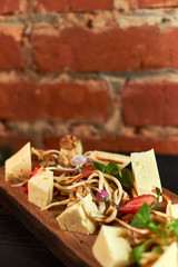 Pieces of cheese on a board with vegetables hd