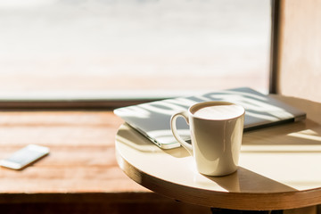 Laptop, a cup of coffee and smart phone on the table in the cafe