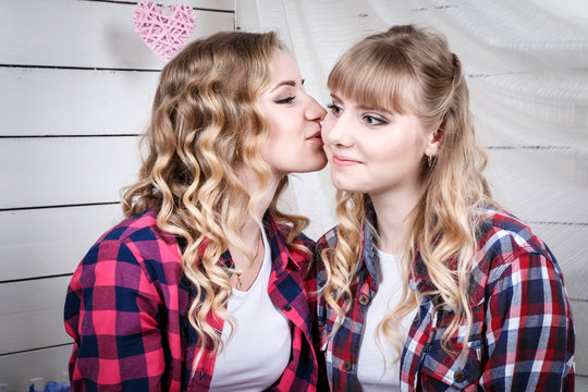 Two blond sisters in the room with white walls