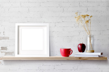 Wood shelf with blank white frame and coffee. Blank screen for products or graphic montage.