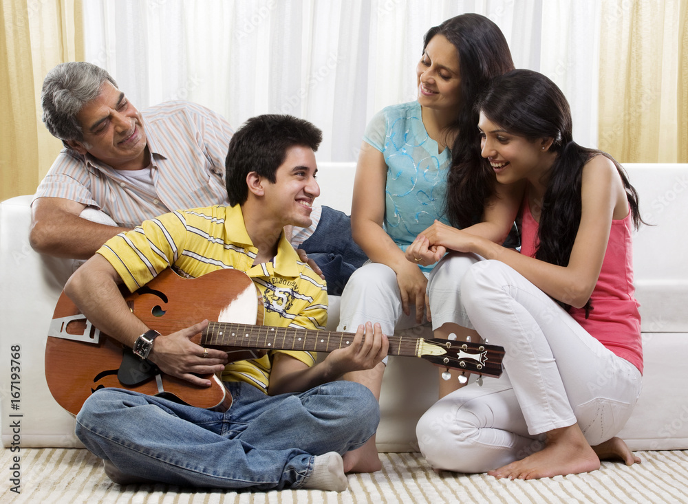 Wall mural boy playing the guitar for his family