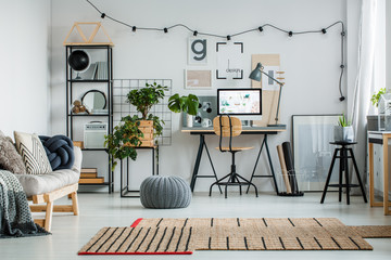 Grey pouf on glossy white floor