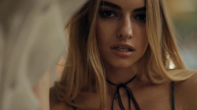 Attractive sexy fashion model closeup portrait in a city street, slow motion