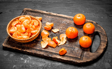 Peeled tangerines with green leaves.