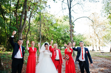 Wedding couple and groomsmen with bridesmaids drinking champagne in the forest.