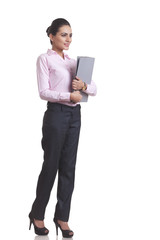 Full length of Indian businesswoman holding file folder over white background
