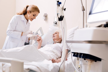 Fototapeta premium Aged bright woman specifying some details of her treatment