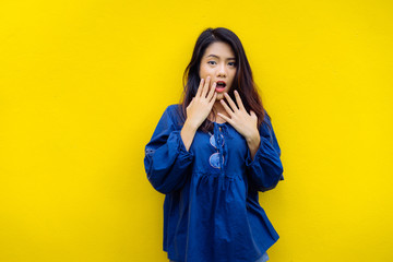 Young girl asian shocked product sale with glasses  on yellow backgrond studio