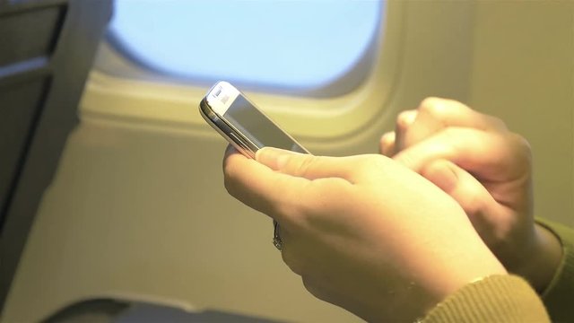 High quality video of woman using phone in the airplane in 4K