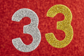 Number thirty-three yellow silver color over a red background.