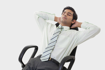 Handsome young businessman relaxing on chair