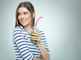 Smiling woman looking side holding green cocktail