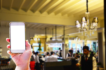 Hand holding smartphone on the restaurant background