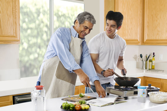 Father and son cooking food in the kitchen 
