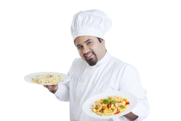 Portrait of chef holding plates with pasta