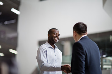 Businessmen shaking hands in a corporate office