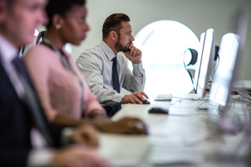 Businessman using computer in crowded office