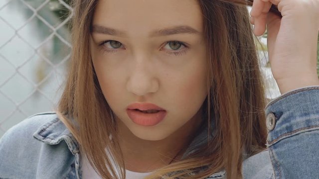 Seductive looking and posing at camera by teen female model. Slowly