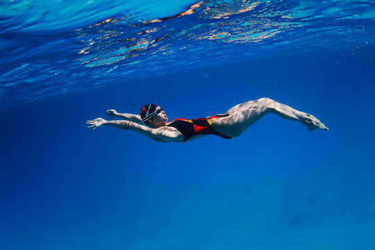 Female Professional Swimmer Gushing Through Blue Red Sea Water With Bubbles