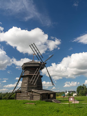 Fototapeta na wymiar Old wooden windmill in Suzdal, Russia. The windmill's blades act like a rotating fan which pushes the rod attached to it to the direction the wind is blowing. 