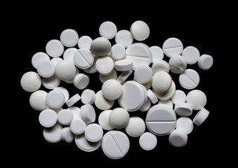 Medical white pills on a black background