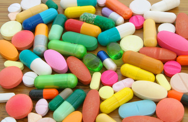 Colorful drugs on wooden table