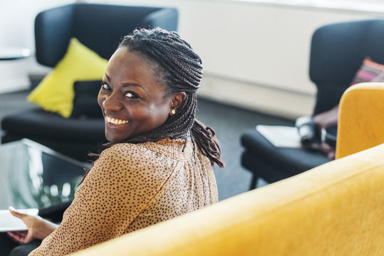 Smiling woman sitting on sofa