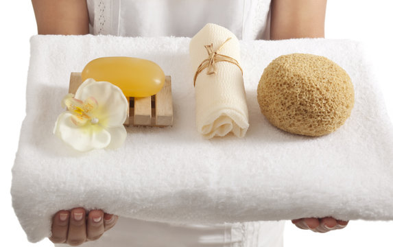Woman holding a towel with bath products 