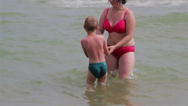 Woman splashing water on her son