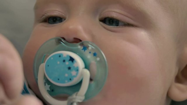 Portrait of cute little boy with dummy views a bottle
