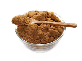 Unrefined light brown cane sugar pile and wooden spoon in glass bowl isolated on white background