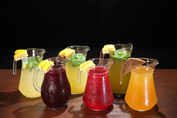 Cold compotes in large glass jars. Summer fruit drinks in glass jugs. Cold lemonades. Lemonade. Morse. Compote.