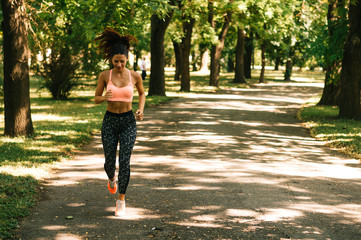 Fit woman running outdoors in park on a sunny day
