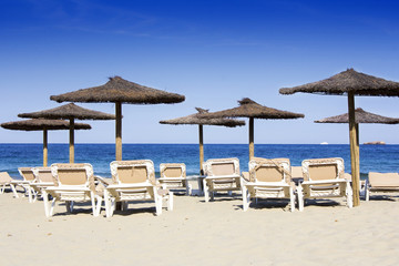 Chairs and umbrellas on a beautiful sandy beach at Ibiza