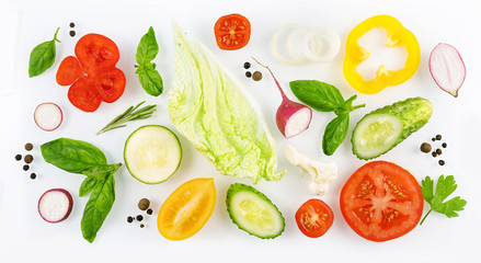 Colorful set of slices of vegetables with spices isolated on white background top view, design for a vegetable menu. Tomato, radish, onion, cucumber, sweet pepper, zucchini, Peking cabbage, basil.